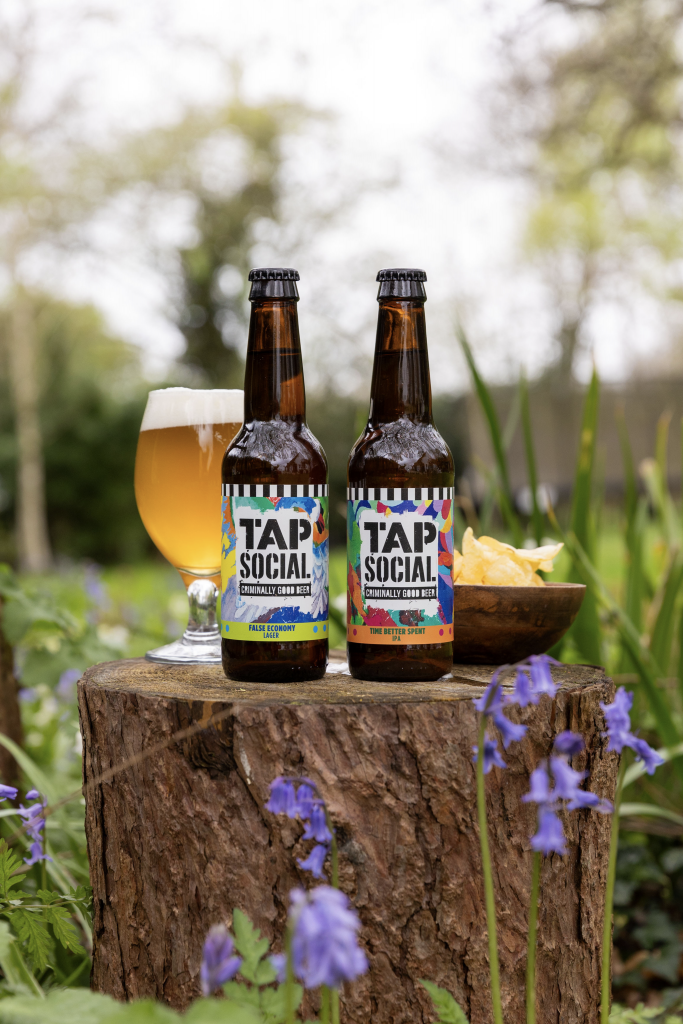 This image depicts two of Tap Social Movement's beers - False Economy Lager and Time Better Spent IPA.