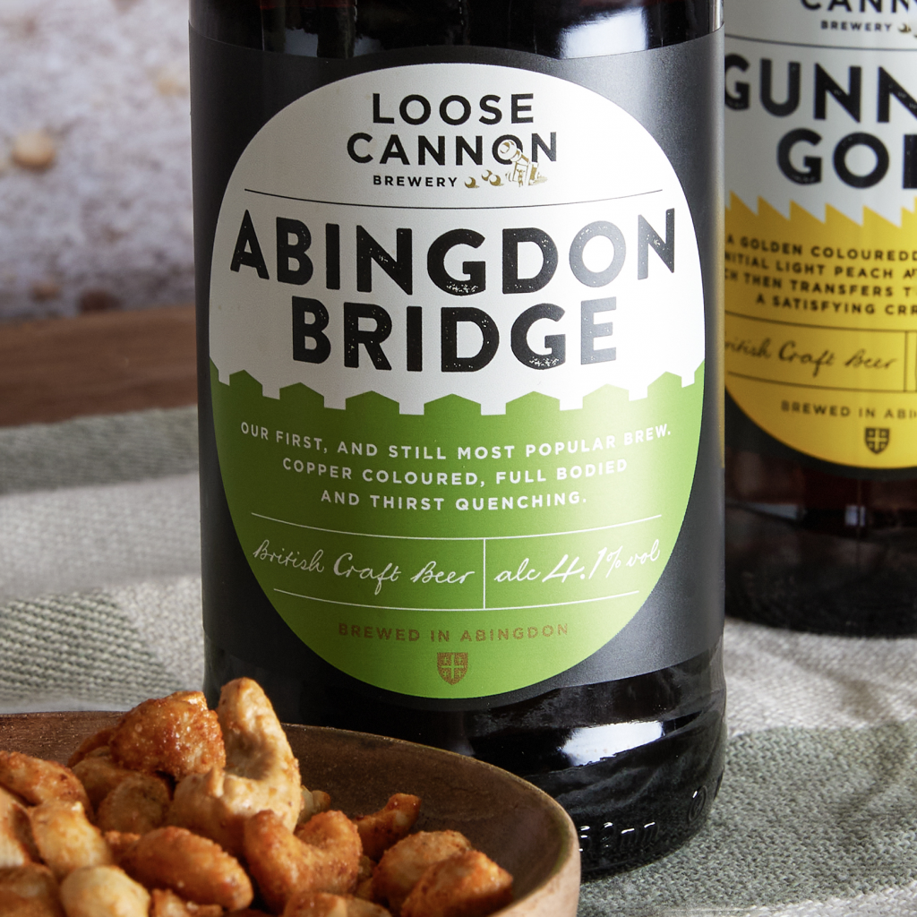 This image shows Loose Cannon Brewery's Abingdon Bridge artisanal craft beer. This beer has a green label and is included in a gift hamper curated by hampers.com called The Gentleman's Tea Hamper.